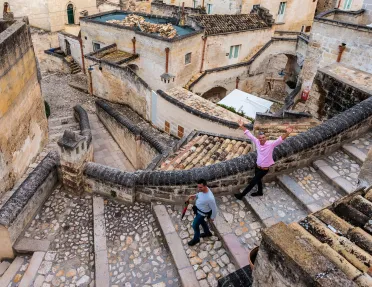 Two men walking through a flight of stone stairs in a town