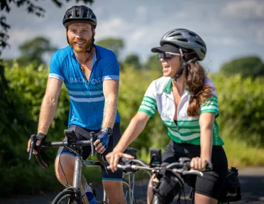 Man and woman riding bikes and smiling