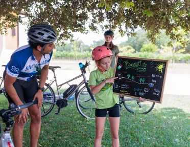 Girl pointing at a chalkboard with a man kneeling down and smiling