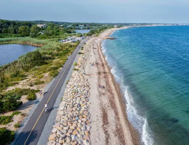 Person riding their bike on a road next to the beach