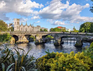 Stone bridge over a river leading to a castle-like building