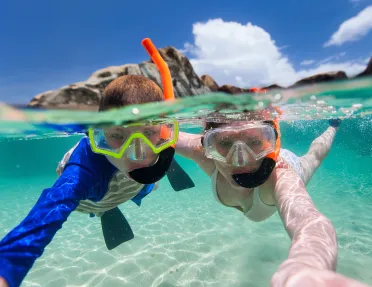 Boy and girl shallow snorkeling in the ocean