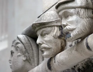 Statue of three men with black specks