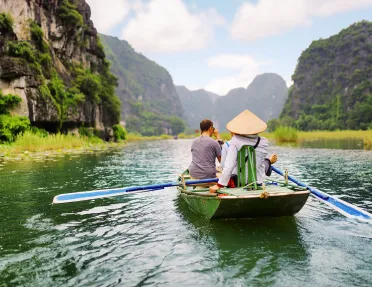 Group of people on a raft, paddling in the middle of a river