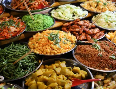 Large plates of noodles and cooked vegetables