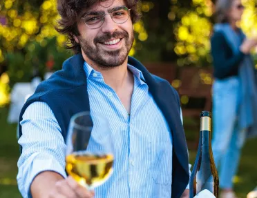 Man smiling while holding a glass of wine