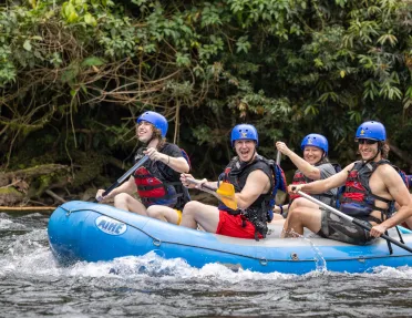 Three Backroads guests whitewater rafting