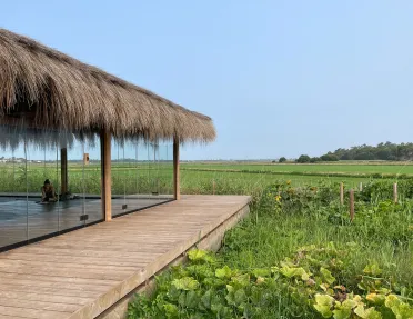 Room and hut with large windows, looking out to a large valley