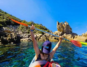 backroads guests holds up paddle while kayaking