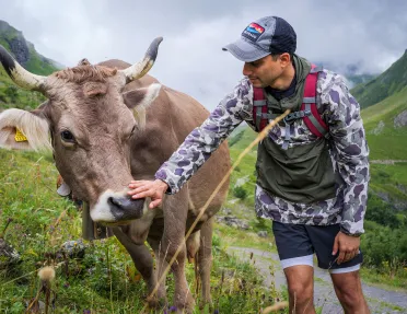 Man petting a cow in the middle of a field