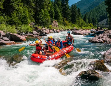 Group of people on a red raft, paddling 