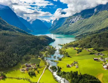 Large valley with houses and crop fields, with a lake in the distance