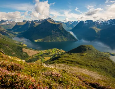 Large valley with grassy mountains and a lake in the center
