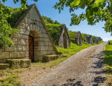 Dirt trail with a row of stone houses to the left