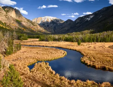 River cutting through a valley with large mountains in the distance