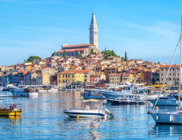 Ocean full of floating boats and a town on a small island
