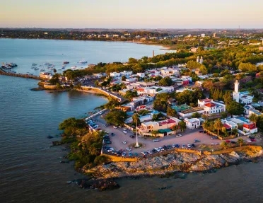 Sky view of small town by the ocean, with cars parked along the beach