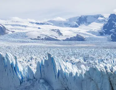 Snow caps and glaciers with mountains in the distance