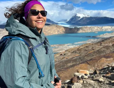 Woman smiling while ascending a rocky hill