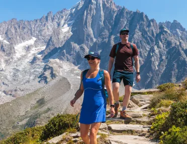 Man and woman descending a path of rocks on top of a mountain