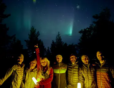 Group of people holding lanterns under the night sky