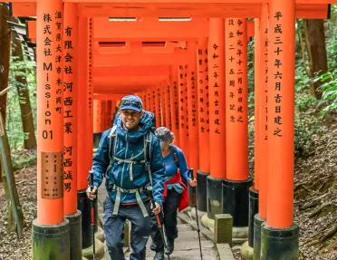 Man and woman smiling while walking along a Japanese shrine