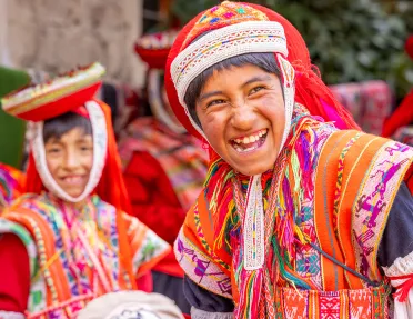 Boy in traditional attire, smiling with a group of other boys behind him