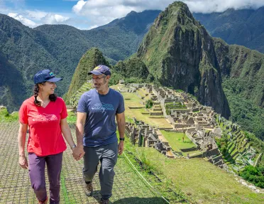 Man and women holding hands, with sights of Machu Picchu in the background