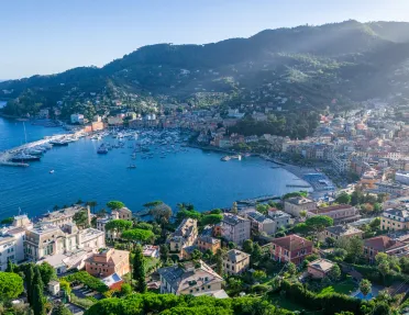 Sky view of large lake surrounded by a town of houses and mountains
