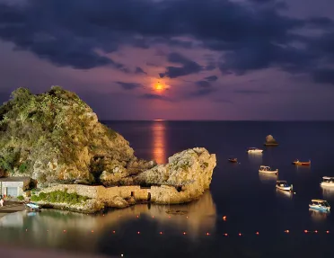 sun setting over an island