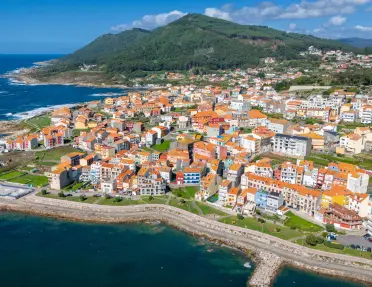 Sky view of town with houses and apartments, surrounded by the ocean