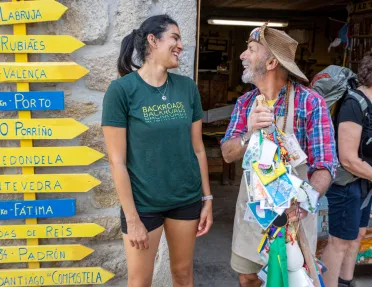 Man and woman smiling next to yellow and blue arrow signs
