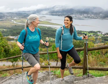 Two women smiling while walking up stairs on a hill