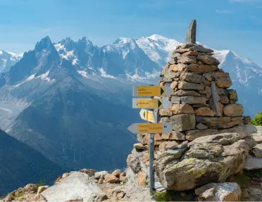 Top of a mountain with a rock pyramid and a wooden sign