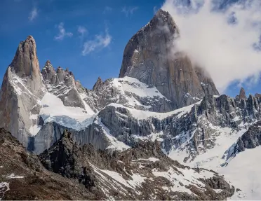 Snowy mountains with foggy clouds in the sky