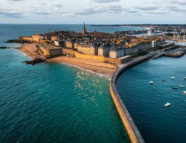 Peninsula town with rustic, European buildings, surrounded by the ocean