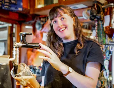 A local bartender filling a pint glass with beer in Ireland.