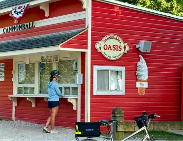 Woman in front of a red building, ordering ice cream