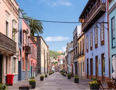 Empty road with tall, colorful buildings on either side