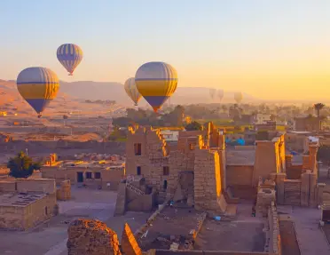 Hot air balloons flying above the Mortuary Temple of Ramesses III at Medinet Habu in Theban Necropolis at Valley of the Kings, Luxor, Egypt.