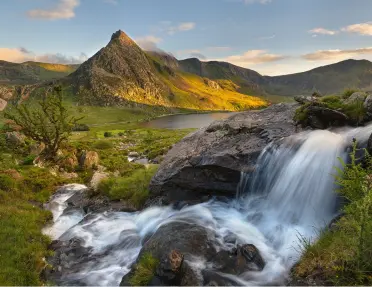 Small waterfall with a tall mountain in the background