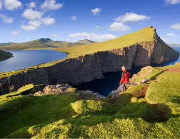 Person hiking on a slanted, grassy hill