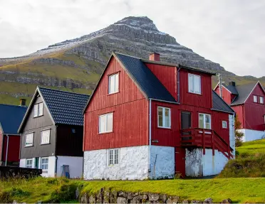 Red and white cottage in the middle of a large valley