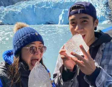 Two kids pretending to eat glacier ice on Alaska's Wilderness & Fjords tour