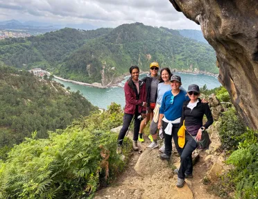 Group of people hiking on a dirt trail with a large river in the background