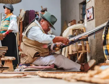 Man weaving fabrics using a tool