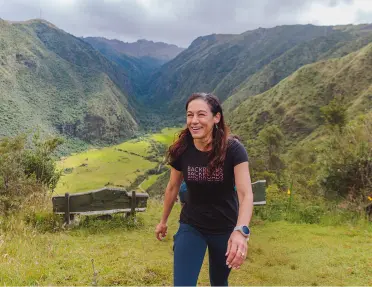 Woman smiling while ascending on a grassy hill