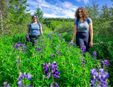 Two women smiling, while walking through a garden