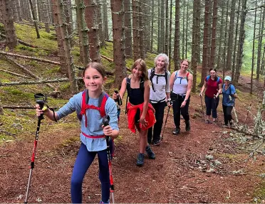 Group of women and girls ascending a trail in a forest