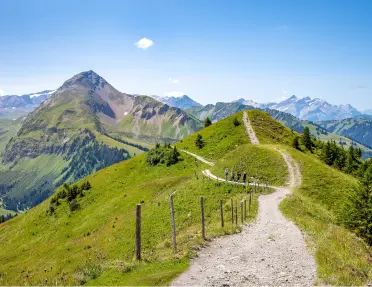 Gravel trail at the top of a mountain, with other mountains in the distance